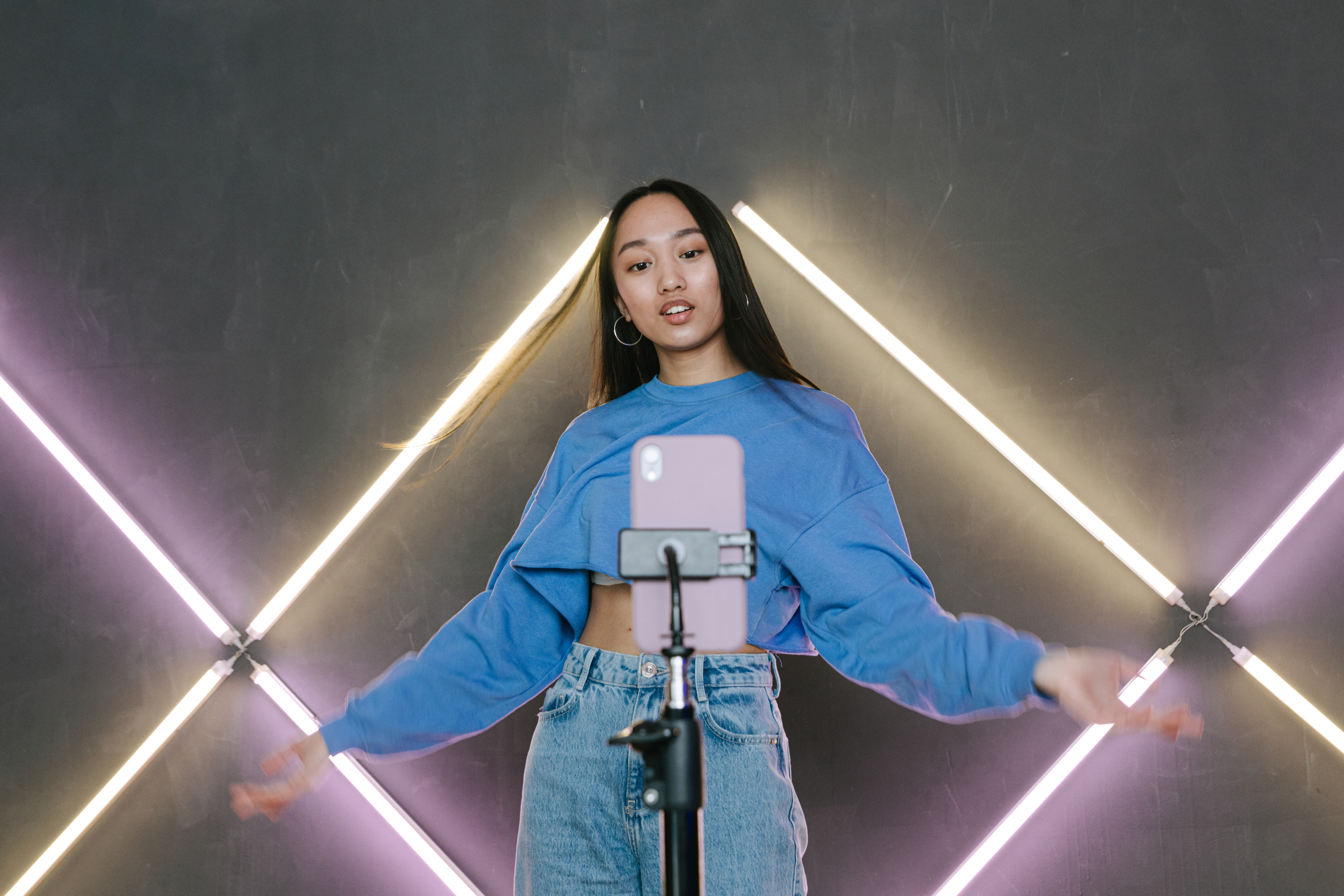 A Woman in Blue Sweater Dancing In Front of Her Mobile Phone on a Tripod